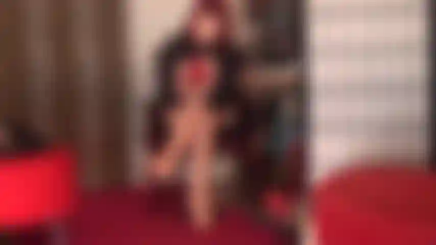 Tentadora de rojo: la amante vivian se pone un par de medias de encaje rojo sobre pantimedias color piel brillante, tacones de aguja rojos y guantes de cuero rojos.