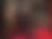 Sexy paja con las manos desnudas y adoración del culo en vestido de vinilo negro brillante, botas altas y medias de encaje.