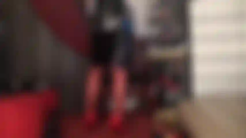 Medias rojas, tacones y falda de vinilo negro brillante.