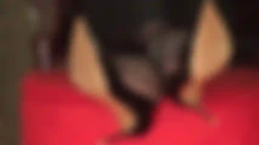 Colgando y jugando con los zapatos, con los tobillos cruzados y los pies sobre una otomana.