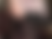 Provocativa erótica sensual con hombros descubiertos, axilas y escote en corset de cuero negro, piernas y medias semiopacas negras.