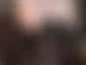 Provocativa erótica sensual con hombros descubiertos, axilas y escote en corset de cuero negro, piernas y medias semiopacas negras.