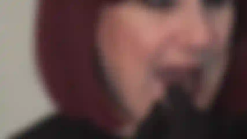 Mis labios rojos brillantes te hacen caer de rodillas: la amante aplica lápiz labial rojo y se burla con su boca seductora, lamiendo lentamente sus labios.