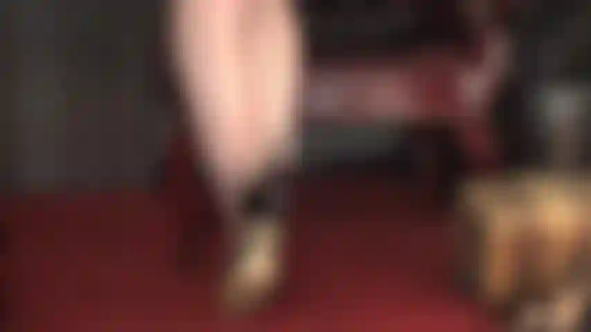 La ama exige adoración por sus seductoras costuras negras y sus tacones de aguja, con su fusta marcando el camino.