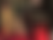 Traje de látex caliente para adorar: falda y blusa verde humo, guantes largos negros y medias de goma transparente con costura con tacones rojos en contraste.