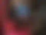 Vestido de látex azul y botas hasta el muslo brillantes.