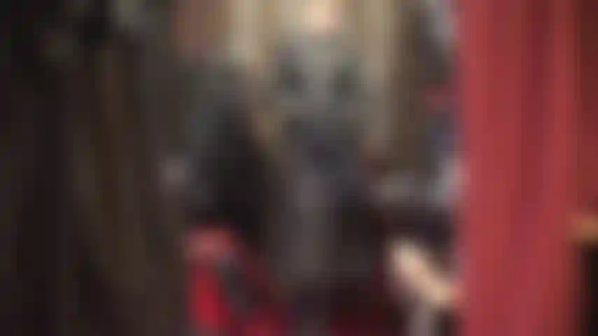 Amante del culto, con un hermoso abrigo largo de cuero, botas altas y guantes.