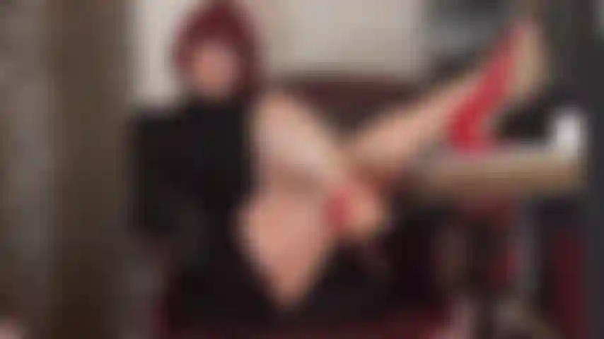 Una jefa sexy con sus piernas en pantimedias largas y brillantes y sus tacones sobre el escritorio.