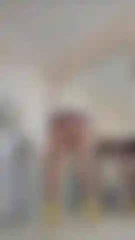 Vestido de látex muy corto, pantimedias y senos provocativos.