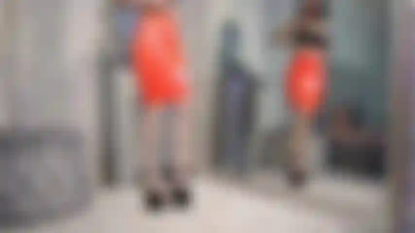 Falda de látex aceitada, tetas y coño destellantes.