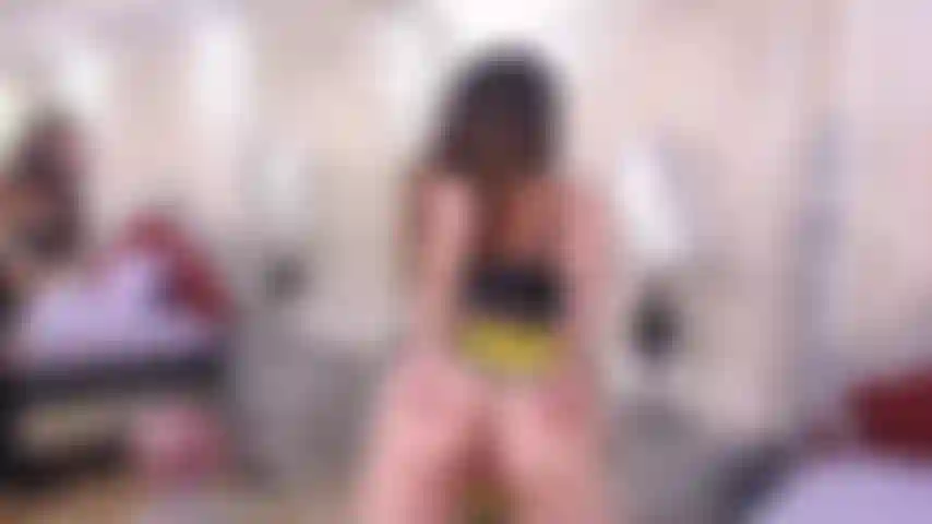 Pequeña rubia haciendo striptease y quitándose la ropa.