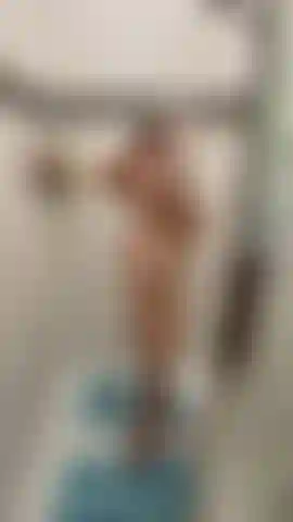 Desnuda y mojada en la ducha con vista frontal y trasera.