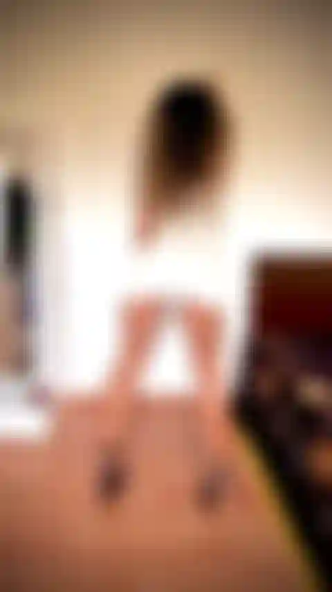 Pantorrillas e isquiotibiales increíbles flexionándose con un vestido blanco corto y ajustado, inclinada contra la pared, sin bragas.
