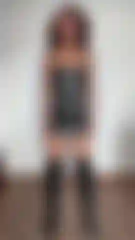 Flexiona los bíceps y llevo un vestido y botas de cuero negro.