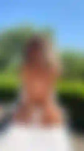 En topless tomando el sol, frente a ti de rodillas.