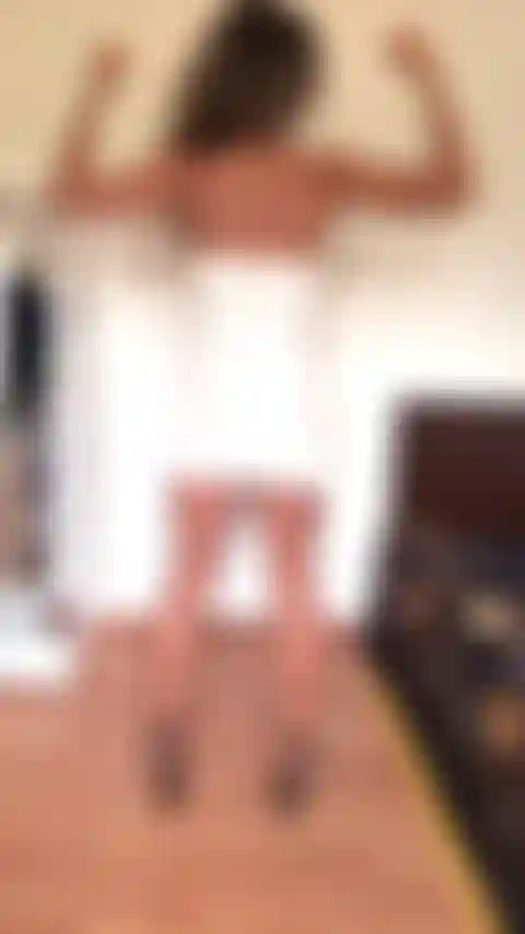 Con la espalda flexionada con mi pequeño vestido blanco ajustado.