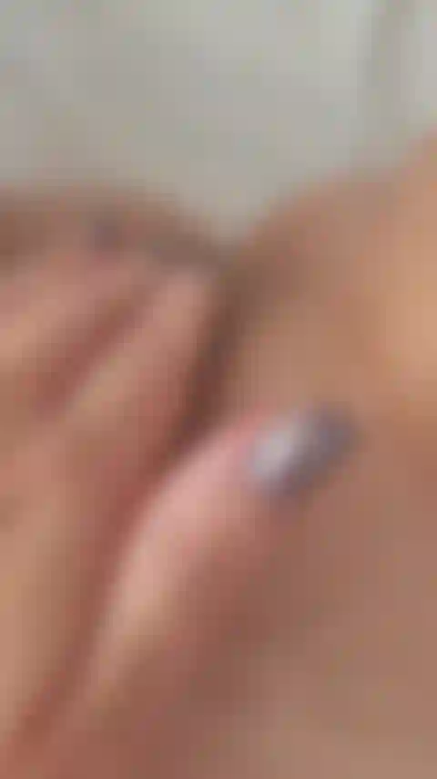 Masturbación en primer plano de coño peludo con uñas brillantes.