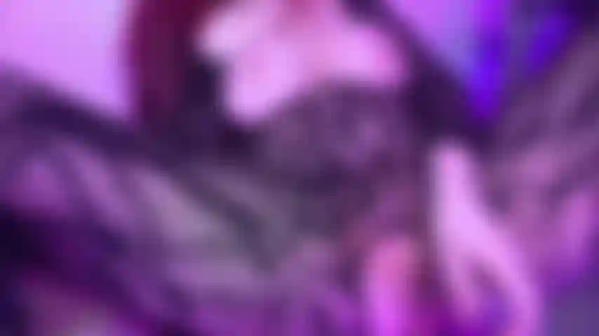 Una estrella porno gótica con curvas folla un coño peludo y mojado con un consolador de cristal rosa en lencería tipo body de encaje negro sin entrepierna.