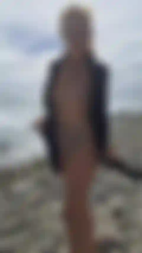 En la playa poso desnuda para la cámara.